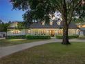 Stunning exterior featuring manicured landscaping, a circular drive, and a charming white facade at 18577 Clay Hill Rd, Dade City, FL 33523