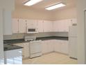 Functional kitchen with white cabinetry, essential appliances, and ample counter space at 1922 Sassafras Dr, Wesley Chapel, FL 33543