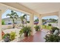 Cozy porch with potted plants, tile flooring, and an ornate gate, creating a welcoming entrance at 202 Grayson Ct, Sun City Center, FL 33573