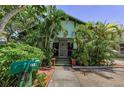 Charming bungalow with lush landscaping and a welcoming front porch and mailbox at 214 Scotland St, Dunedin, FL 34698