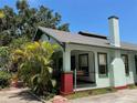 Charming home featuring a cozy front porch with a swing and a lush, landscaped yard at 214 Scotland St, Dunedin, FL 34698
