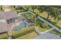 Aerial view of a backyard oasis featuring a screened-in pool and fenced yard at 2146 Gold Dust Ct, Trinity, FL 34655