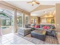 Open-concept living room with tile flooring, large sectional sofa, and sliding glass doors to the pool area at 2146 Gold Dust Ct, Trinity, FL 34655