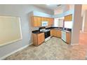 Bright kitchen with light wood cabinets, black countertops, and a full suite of appliances at 2614 Queen Alberta Dr, Valrico, FL 33594