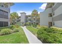 Condo complex exterior showcasing courtyard, manicured landscaping, and walkways at 2650 Countryside Blvd # A210, Clearwater, FL 33761