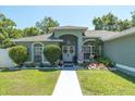 Welcoming front entrance with double doors, decorative wreaths, and manicured landscaping at 2826 Martha Ln, Land O Lakes, FL 34639