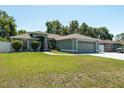 Beautiful single-story home featuring a well-manicured lawn, arched windows, and an attached two-car garage at 2826 Martha Ln, Land O Lakes, FL 34639