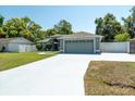 Charming single-story home features a two-car garage, well-maintained lawn, and mature trees at 2826 Martha Ln, Land O Lakes, FL 34639