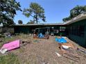 Backyard of a single story home featuring various objects scattered around the lawn at 314 Dickman Sw Dr, Ruskin, FL 33570