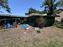 Backyard of a single story home featuring various objects scattered around the lawn at 314 Dickman Sw Dr, Ruskin, FL 33570