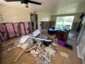 Dilapidated living room needing renovations, showing exposed walls and damaged flooring at 314 Dickman Sw Dr, Ruskin, FL 33570