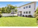 Spacious backyard with lush green grass and tropical foliage surrounding the home at 3616 W Anderson Ave, Tampa, FL 33611