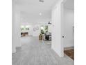 Hallway leading to a living room, kitchen, and dining area in an open-concept design at 3616 W Anderson Ave, Tampa, FL 33611