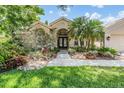 Charming home exterior featuring lush landscaping and a welcoming entrance at 4320 Auston Way, Palm Harbor, FL 34685