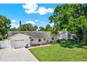 A well-maintained home with a large front yard and a brick facade showcasing curb appeal at 5008 Stolls Ave, Tampa, FL 33615