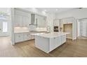 Modern kitchen with white cabinets, stainless steel appliances, and a spacious island perfect for cooking and entertaining at 5116 Wildwind Dr, Apollo Beach, FL 33572