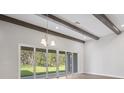 Bright living room featuring wooden beams, lots of space and sliding glass doors offering seamless indoor-outdoor living at 5116 Wildwind Dr, Apollo Beach, FL 33572