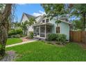 A beautiful light blue home featuring a spacious, screened-in front porch and well-manicured green lawn and garden at 535 31St N Ave, St Petersburg, FL 33703
