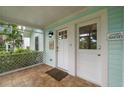 Cozy screened-in front porch with a light blue exterior, welcoming front door, and a glimpse of the well-kept front yard at 535 31St N Ave, St Petersburg, FL 33703