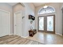 Bright foyer with tiled floor, bench seating, decorative double doors, and soaring ceilings at 6519 Twin Bridges Dr, Zephyrhills, FL 33541