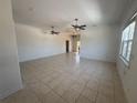 Spacious living room with tile flooring, crown molding, and ceiling fans at 7330 New York Ave, Hudson, FL 34667
