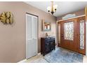 Elegant foyer featuring a decorative front door, stylish lighting, and a beautiful cabinet and mirror at 8315 W Elm St, Tampa, FL 33615