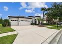 Beautiful single-story home showcasing a spacious driveway, three-car garage, and lush front yard at 8413 Swiss Chard Cir, Land O Lakes, FL 34637