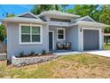 Beautifully landscaped single-story home featuring a gray exterior with a one-car garage at 8608 N Arden Ave, Tampa, FL 33604