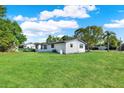 Spacious green backyard featuring mature trees and bright home exterior at 9266 Century Dr, Spring Hill, FL 34606