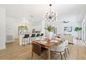 Open-concept dining room with modern chandelier, seamlessly connecting to the kitchen and living area at 970 Ridgewood Ter, Tarpon Springs, FL 34689