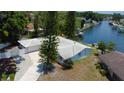 Aerial view of single-story home situated on waterfront property with private dock and lush landscaping at 10744 Drummond Rd, Tampa, FL 33615