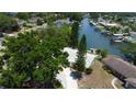 Aerial view of single-story home situated on waterfront property with private dock surrounded by mature trees at 10744 Drummond Rd, Tampa, FL 33615
