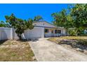 Inviting single-story home with an attached garage and manicured front yard landscaping at 11735 86Th Ave, Seminole, FL 33772