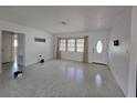 Bright living room with terrazzo floors, a large window with blinds, and a classic front door at 11735 86Th Ave, Seminole, FL 33772