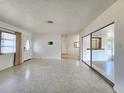 Spacious living room featuring polished terrazzo floors, a sliding glass door, and abundant natural light at 11735 86Th Ave, Seminole, FL 33772