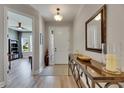 Bright entryway featuring wood-look floors, stylish console table, and views into the living spaces at 12957 Satin Lily Dr, Riverview, FL 33579