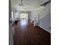 Open-concept living area with hardwood floors, neutral paint, and staircase access to the upper level at 13157 Kings Crossing Dr, Gibsonton, FL 33534