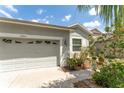 Lovely home exterior with a two car garage and vibrant flower beds at 13803 Chalk Hill Pl, Riverview, FL 33579