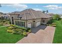 Expansive home showcasing its tile roof, three-car garage, and well-maintained lawn and landscaping at 14715 Fishhawk Preserve Dr, Lithia, FL 33547