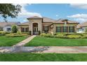 Beautiful single-story home featuring stone accents, tile roof, and lush front lawn with manicured landscaping at 14715 Fishhawk Preserve Dr, Lithia, FL 33547