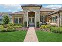 Charming home featuring a brick pathway, double door entrance, and professionally landscaped front yard at 14715 Fishhawk Preserve Dr, Lithia, FL 33547