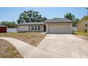 Well-maintained single-story home with a two-car garage, manicured lawn, and a tidy walkway to the entrance at 1818 Willow Oak Dr, Palm Harbor, FL 34683