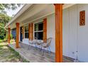 Inviting front porch with stylish seating and wooden columns and trim at 2750 Edenwood St, Clearwater, FL 33759