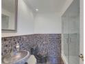 Stylish bathroom featuring modern mosaic tile accents, a glass-enclosed shower, and a sleek, unique stone sink at 31 Freshwater Dr, Palm Harbor, FL 34684