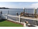 View of a backyard dock and calm waterway featuring a boat lift and a white picket fence overlooking the tranquil water at 31 Freshwater Dr, Palm Harbor, FL 34684
