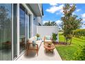 Outdoor patio featuring cozy wicker furniture and view of well-manicured backyard at 31355 Amberview Bnd, Wesley Chapel, FL 33545