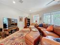 Cozy living room with leather furniture, TV, and large windows at 3138 Nautical S Pl, St Petersburg, FL 33712