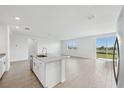Open concept kitchen with granite island seamlessly flows into the living area and sliding glass door at 31647 Malbec Dr, Brooksville, FL 34602
