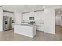 Stylish kitchen featuring white cabinets, stainless steel appliances, and a large center island at 31647 Malbec Dr, Brooksville, FL 34602