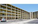 Exterior view of a multi-story condo building with multiple units, parking lot, and balconies in a light color scheme at 3534 Lake Bayshore Dr # 118, Bradenton, FL 34205